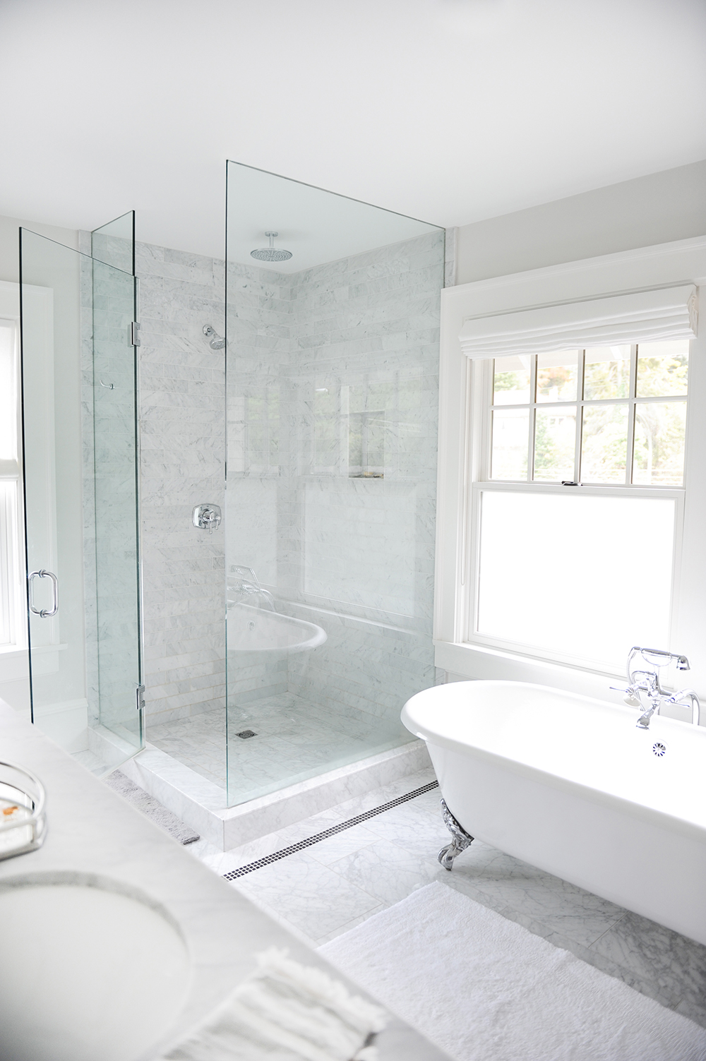 A spacious ensuite with a glass-enclosed shower and clawfoot tub.