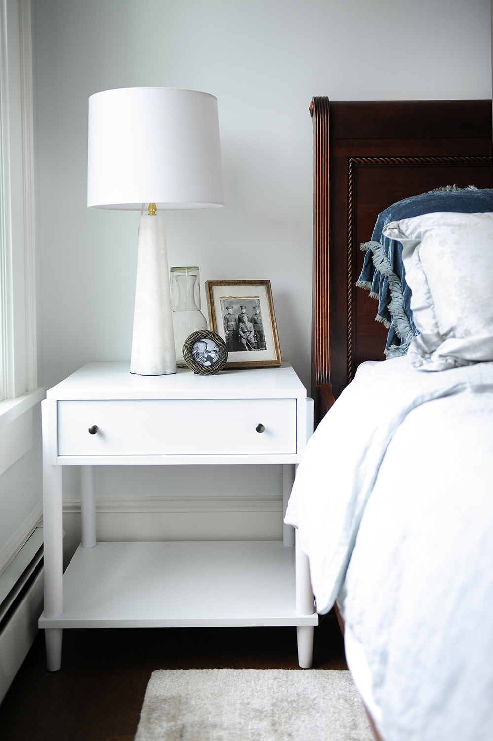 The designers contrasted the owners' wooden bed with white nightstands.