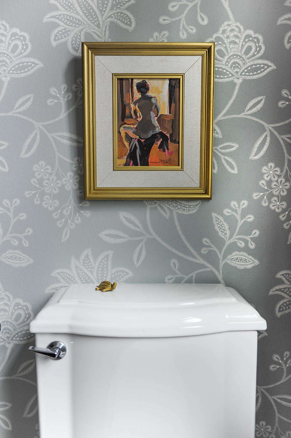 A powder room with sumptuous floral wallpaper and unexpected accents.