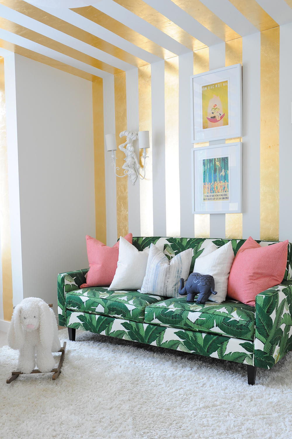 A stylish nursery featuring a tropical palm-leaf patterned sofa.