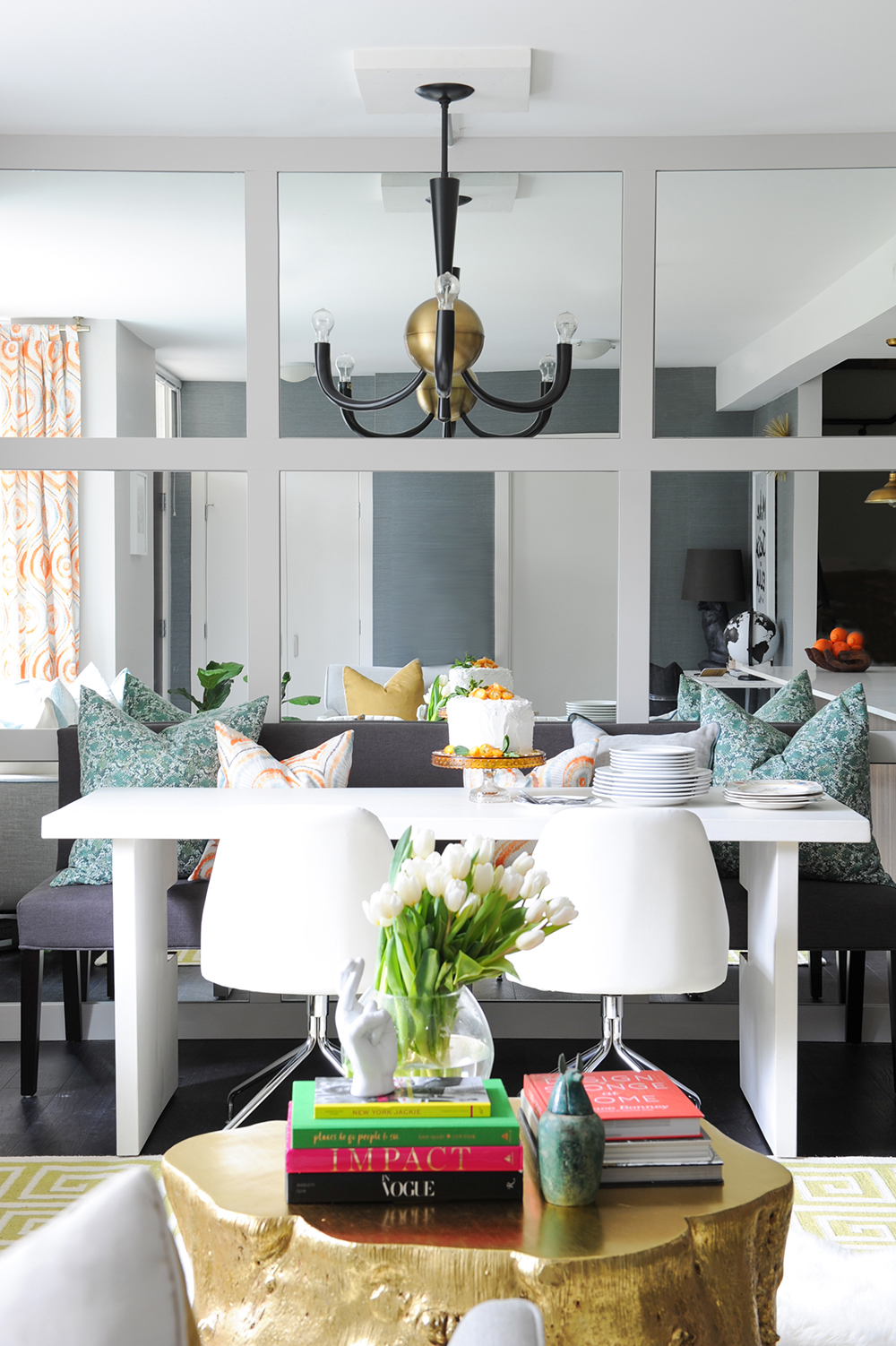 A colourful dining area with a mirrored feature wall.