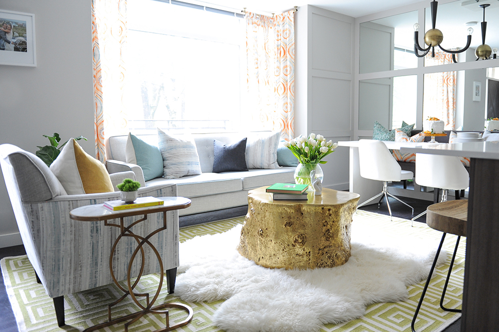 A bright and glam living area with layered area rugs.