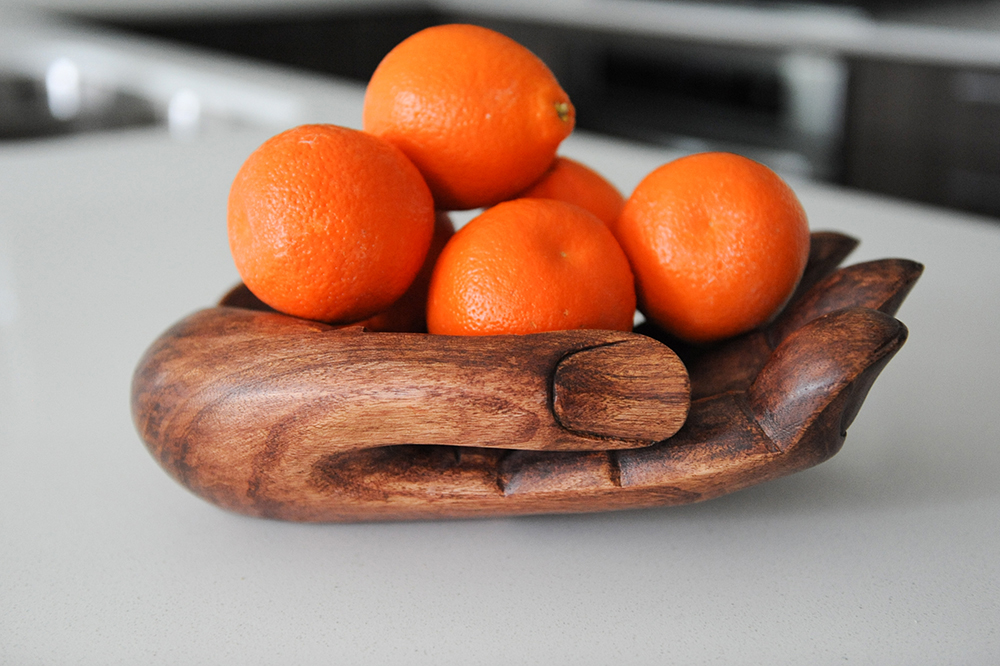 A playful hand-shaped wooden dish.