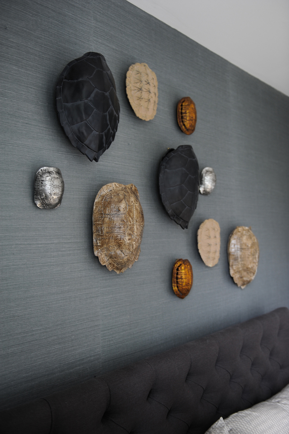 A bedroom feature wall outfitted with faux turtle shells instead of standard artwork.