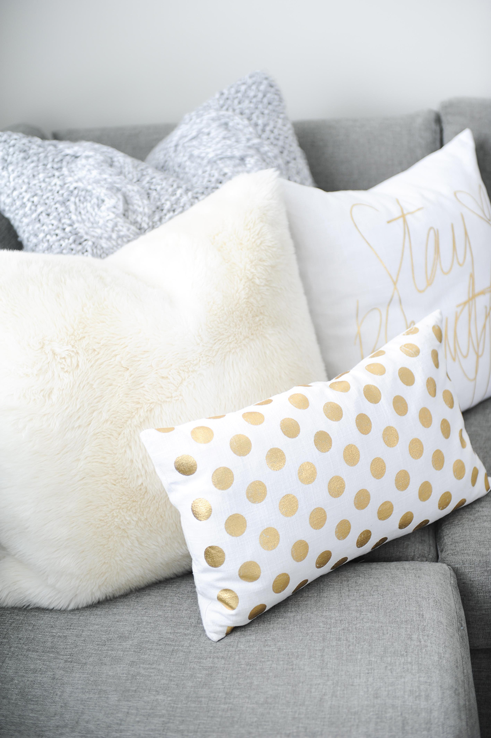 Faux fur and whimsical white and gold toss cushions.