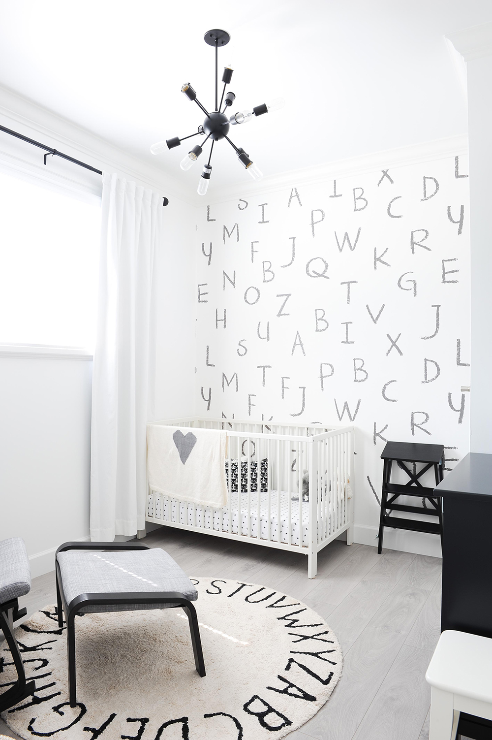 black and white nursery with letters on wall behind the crib