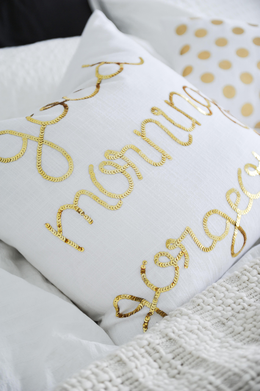 Glam accents like this sequined toss cushion perk up a neutral bedroom.