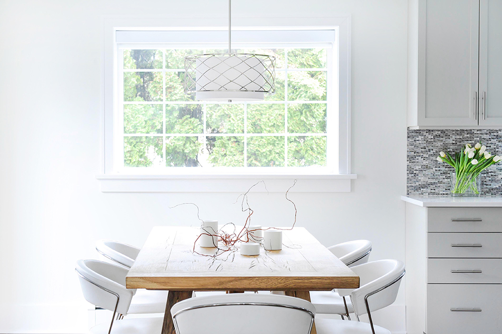Light-filled dining area with warm wood table and modern white seating.