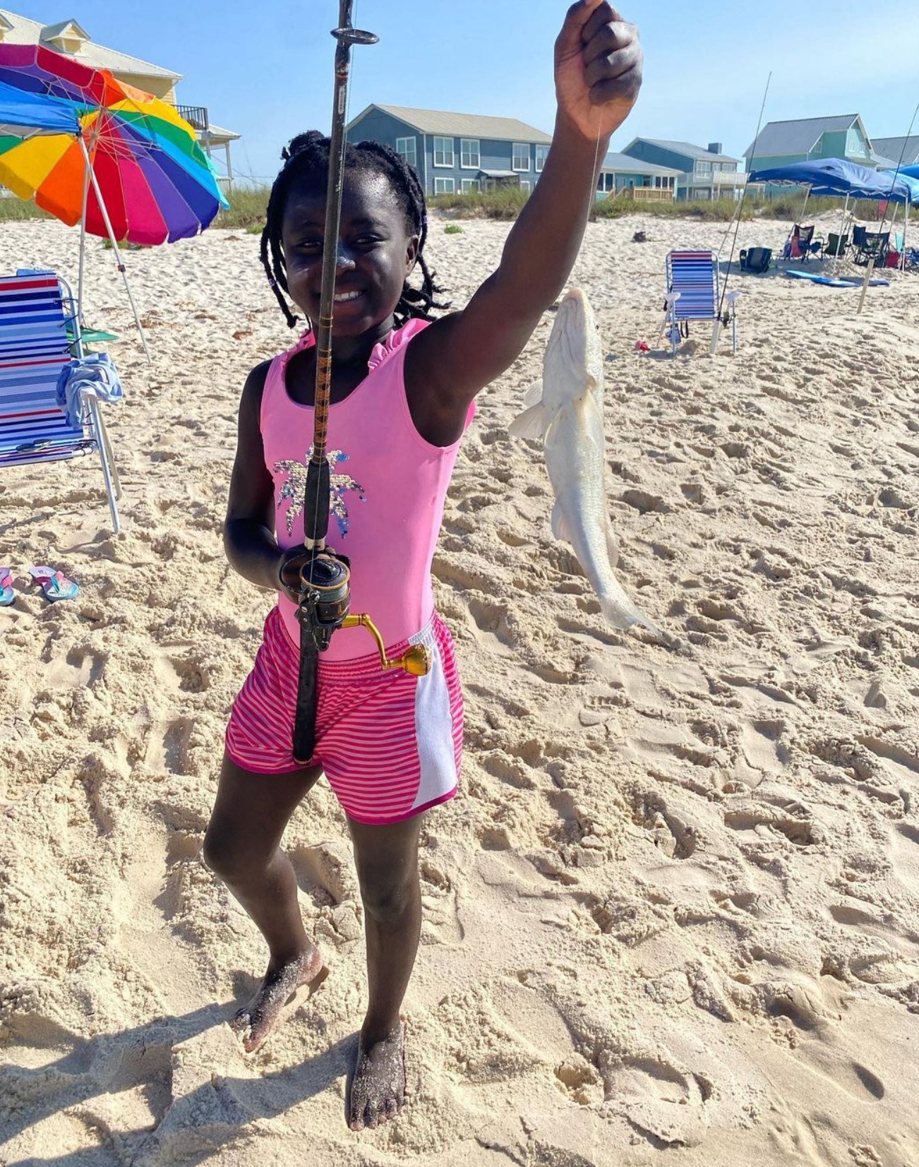 Sylvie Marrs holding up a fish at the beach