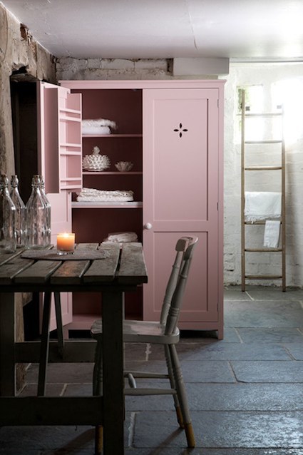 Blush-coloured pink cabinet in farmhouse-style kitchen