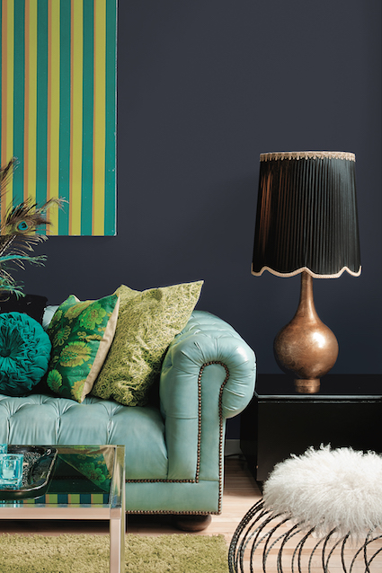 Bright coloured sofa set against a dark painted wall