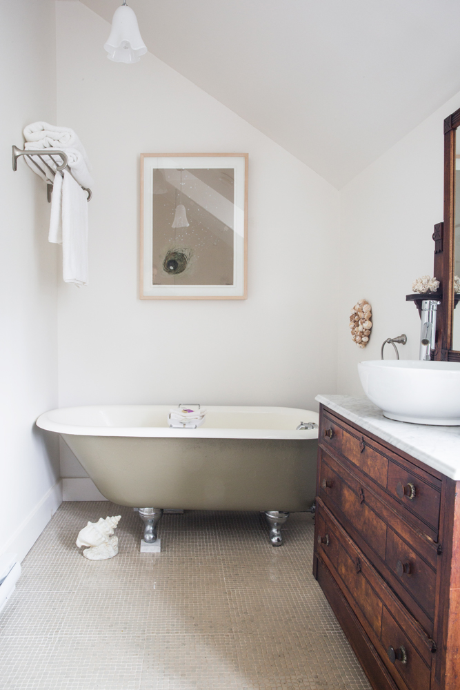 bathroom facing olive green clawfoot tub, white seashell on floor