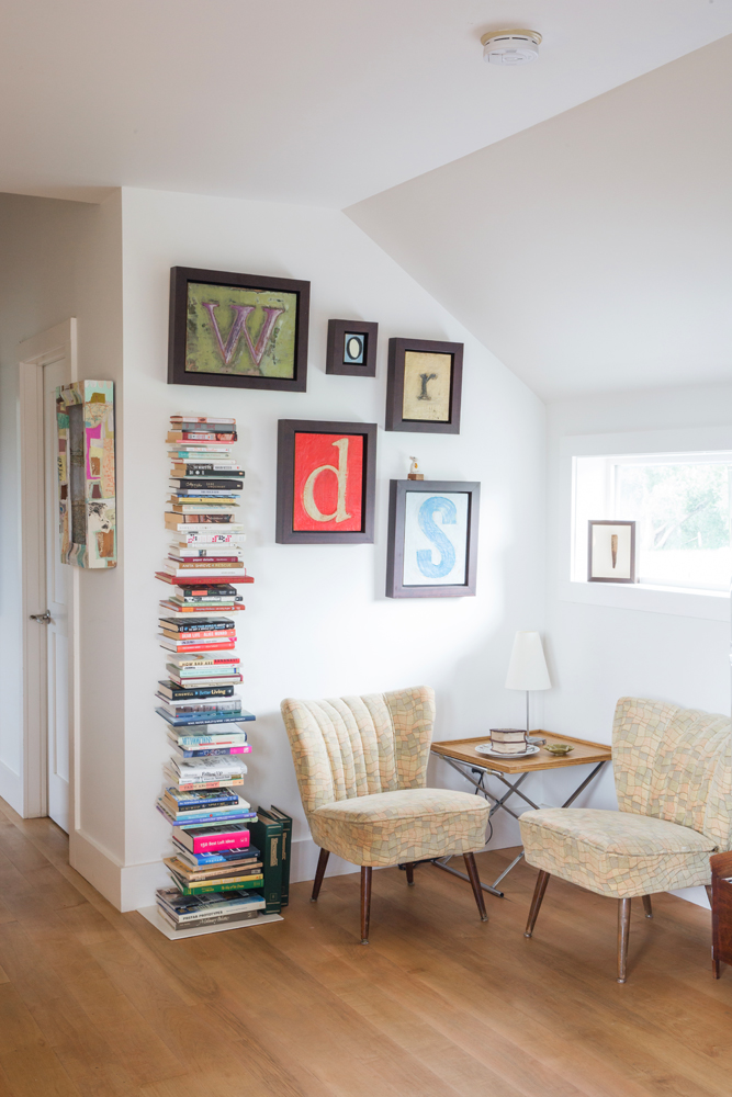 two chairs, vertical book rack, framed letter pics
