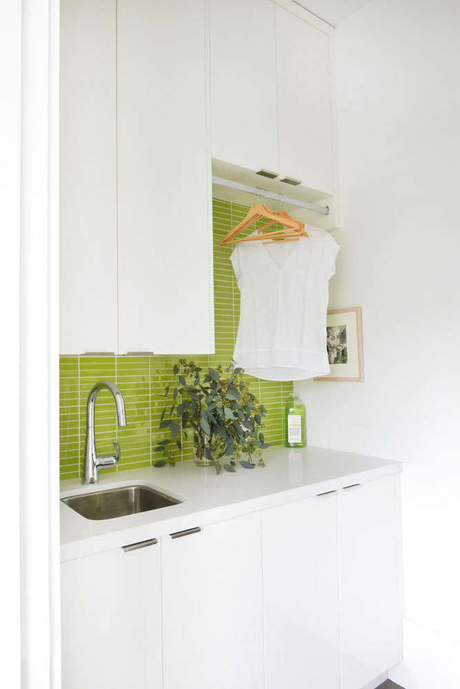 laundry room with green tiled back splash and white shirt hanging