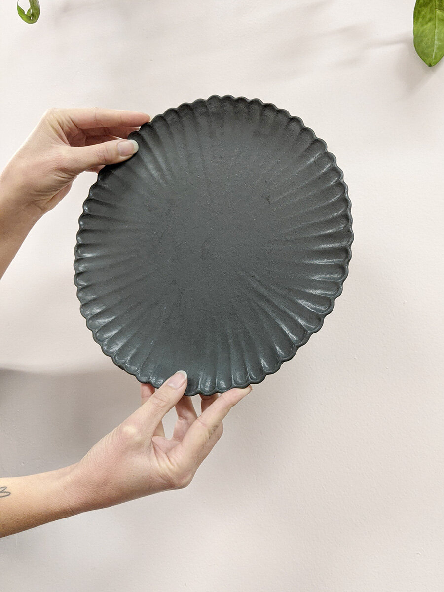 Matte black scallop edge platter made by Eikcam ceramics