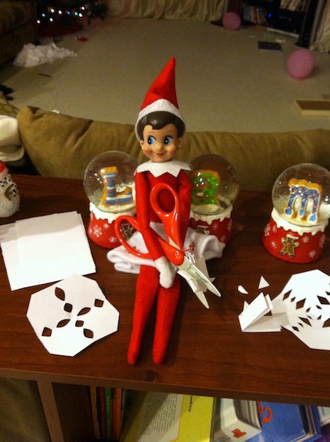 Elf on the Shelf cutting paper snowflakes
