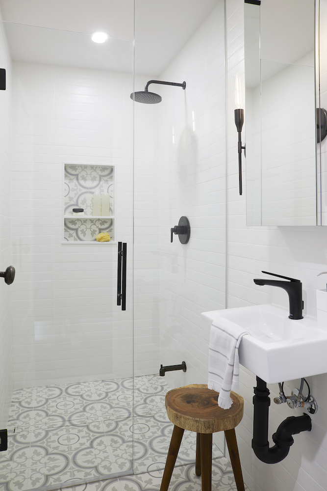 modern white bathroom with glass shower and patterned tile floor