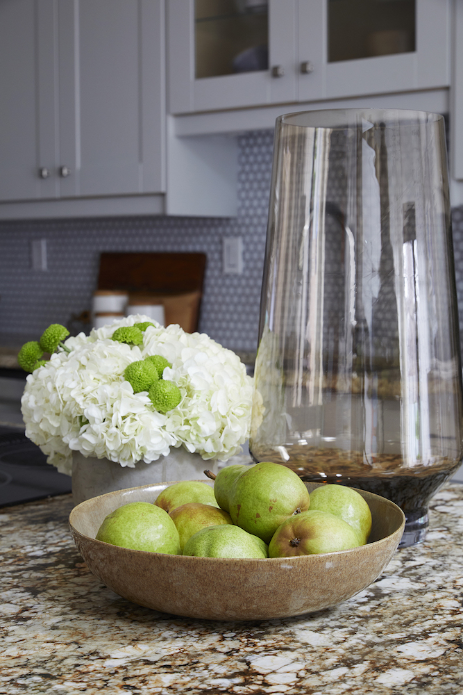 marble kitchen counter with bowl of pears and geometric backsplash in background