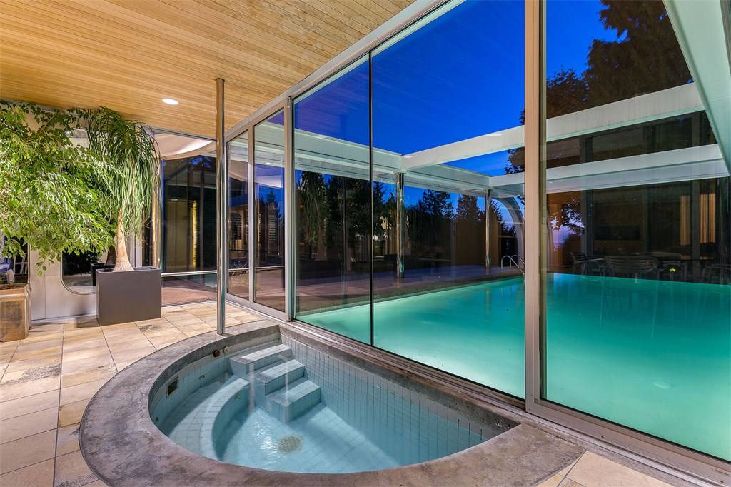An indoor hot tub that opens to the outdoor pool