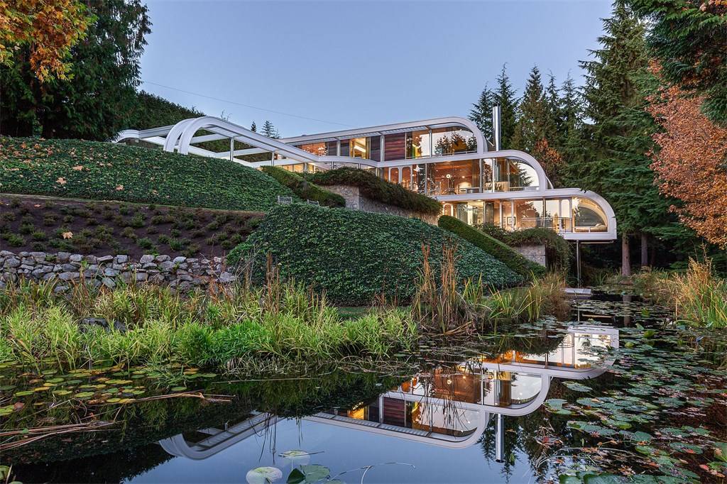 Beautiful green landscaping outside glass and steel mansion in West Vancouver