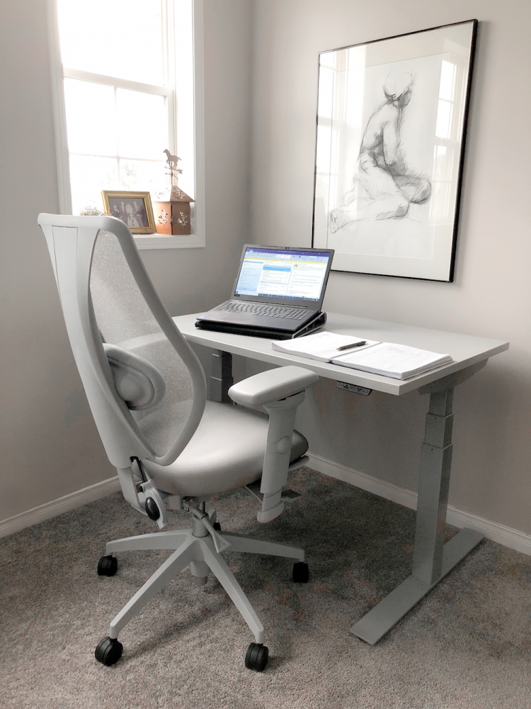 A grey ergonomic chair in a neutral office space