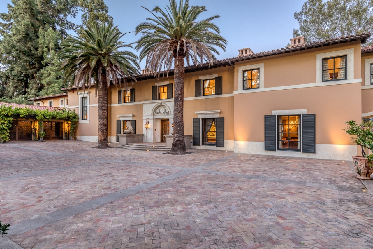 The stunning exterior of a Pasadena mansion with two grand palm trees.