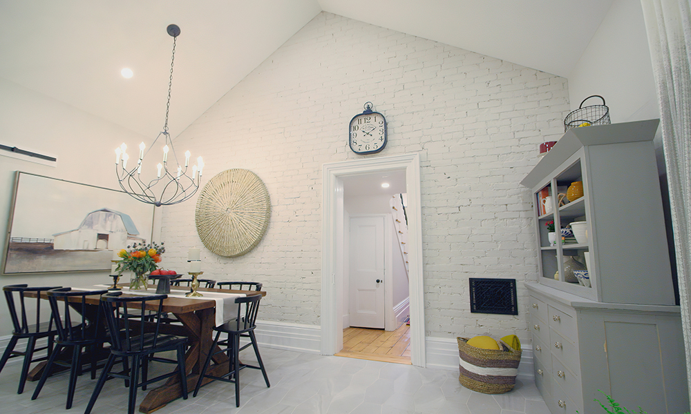 An exposed-brick wall painted white in a kitchen with neutral colours.