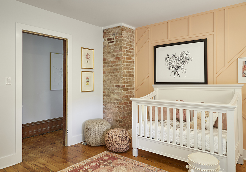 A nursery with peach paint and moulding