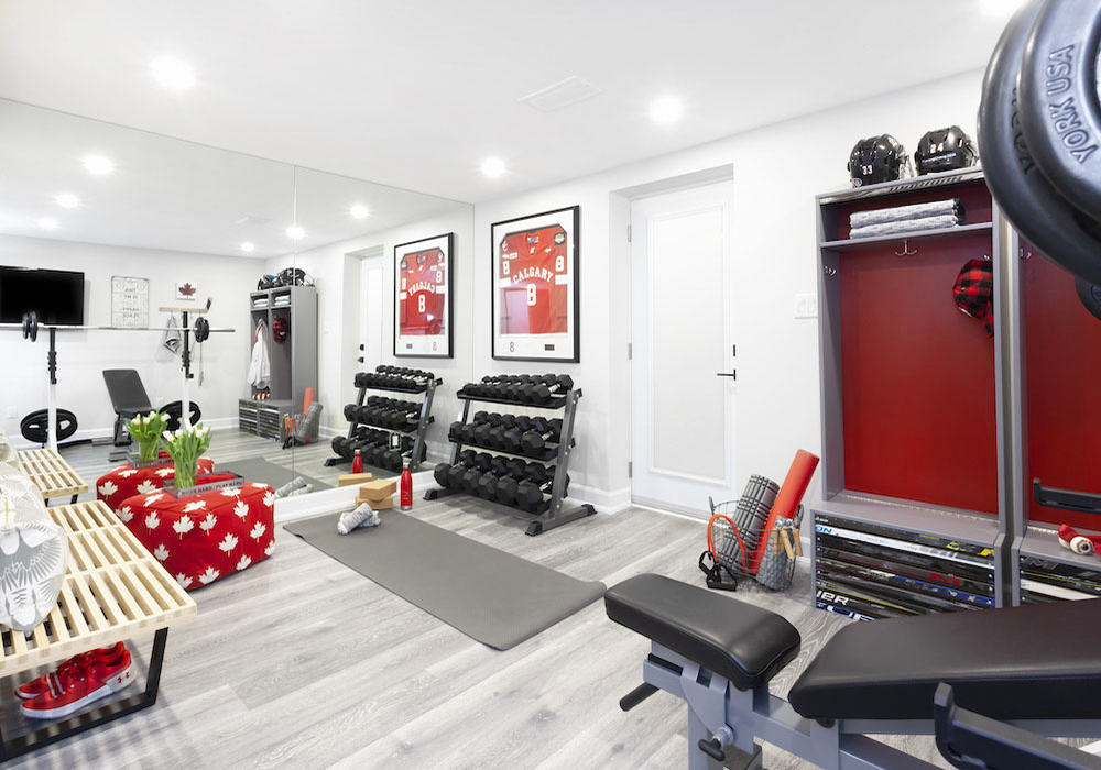 A home gym with dumbbells, weights accompanied by maple leafs to pay homage to Canada.