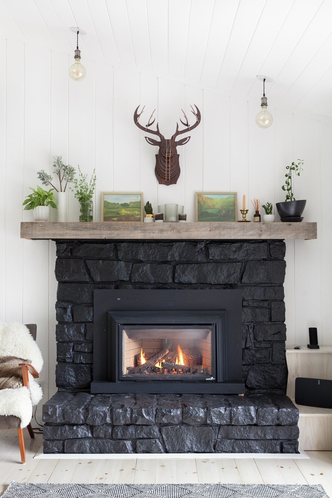 Rustic farmhouse living room with stone fireplace painted black for modern edge.