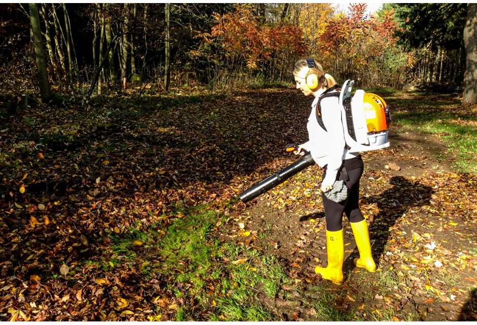 Sarah Baeumler outdoors with a leaf blower