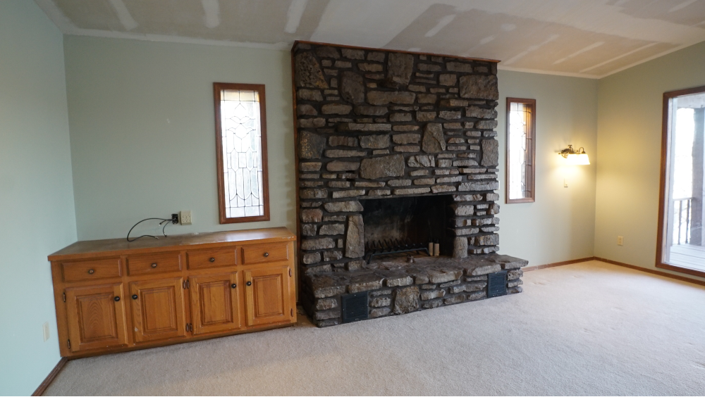 Large stone fireplace in empty lake house