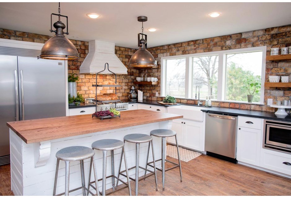 A brick facade can look tired and dated, but when paired with modern upgrades like these stainless steel appliances and the light fixtures, they add the right amount of country charm.