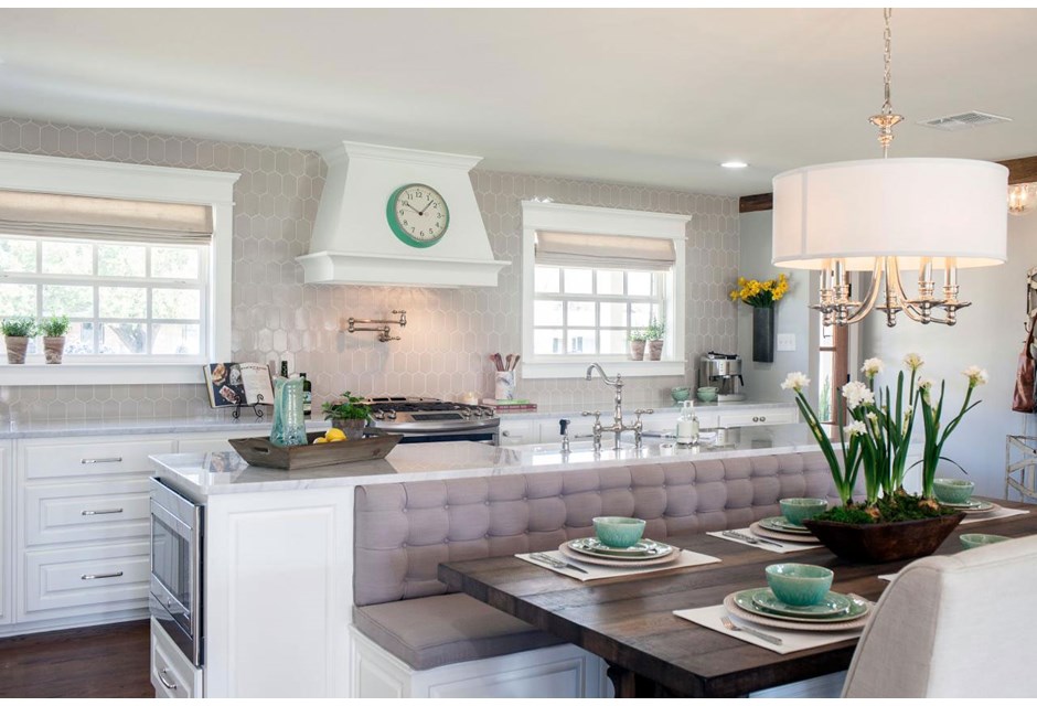Various shades of white combine to make this space feel open and bright. Add in pops of soft green and interesting pieces like the clock over the hood, and you've got a feminine kitchen you'd easily expect to find on a movie set.