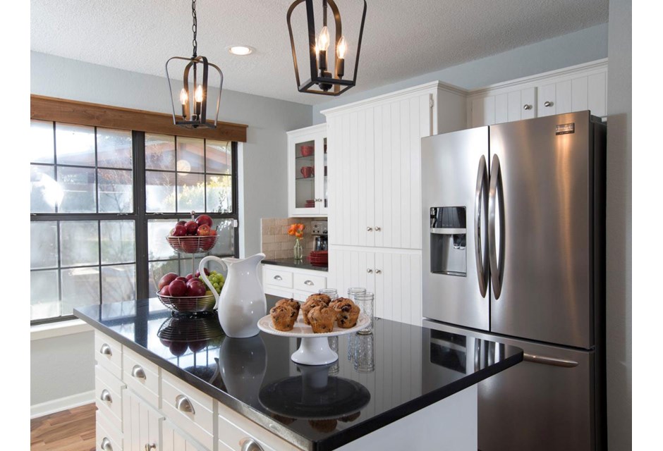 We love these bold light fixtures and the wood trim on the picture window. Those, coupled with the shiplap finish on the cupboards, give this kitchen an updated country vibe we completely covet.