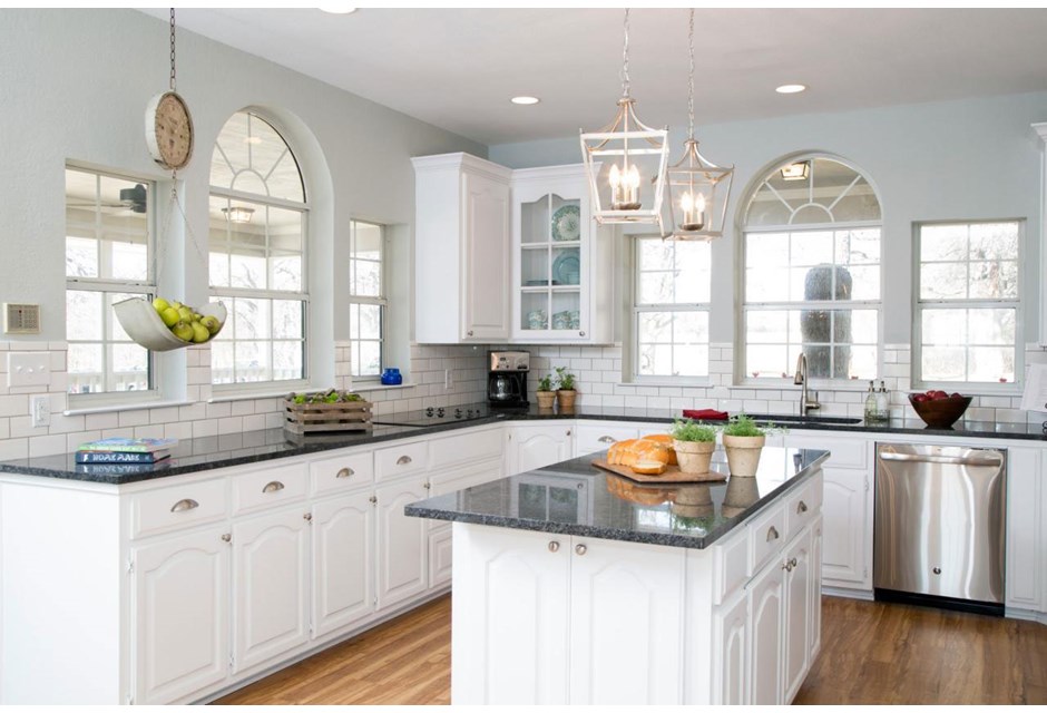 These sparkling white cabinets and island are clean, bright and automatically give the space a modern feel. Add in soft grey walls and darker counter tops to bring the look back to the country.
