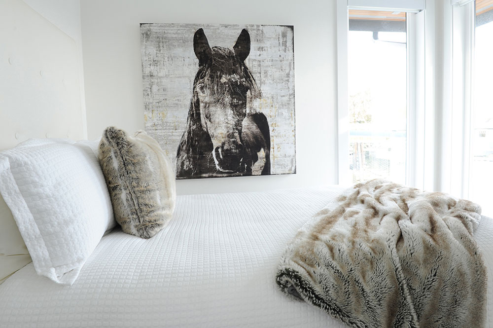 bedroom with horse art and furry cushion and blanket