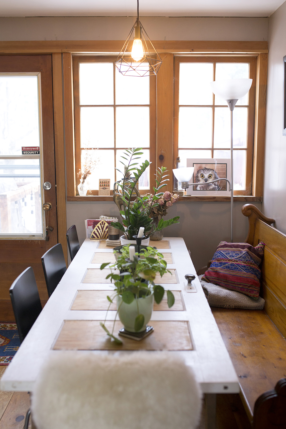 Dining room table with church pew and plants