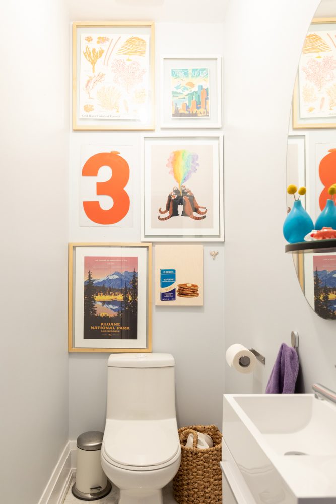 Grey bathroom with colourful gallery wall above toilet