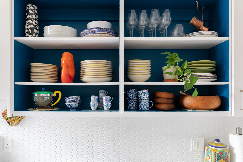 Plates and dishes in blue open shelving in kitchen