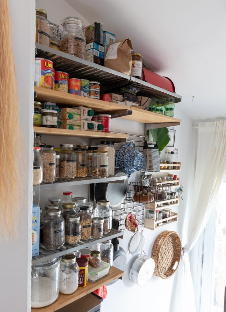 Walk-in pantry with shelves filled with glass jars
