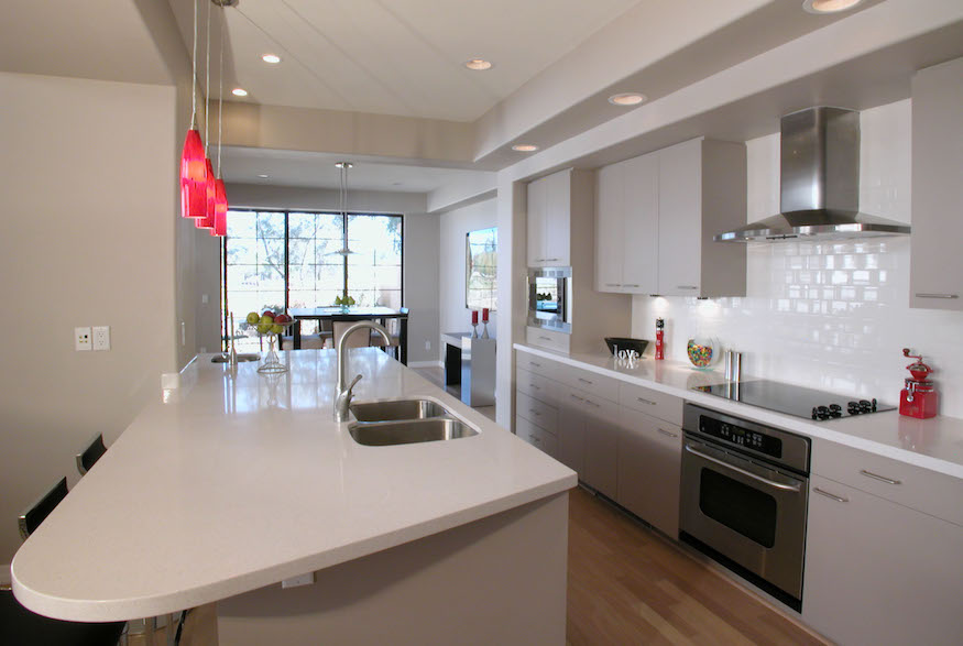 Minimalist galley kitchen with red pendant lights
