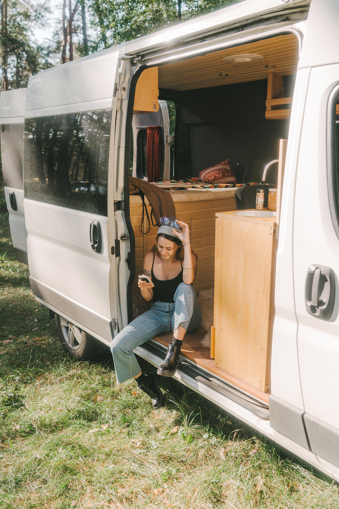 woman in camper van with light wood bed and ceiling
