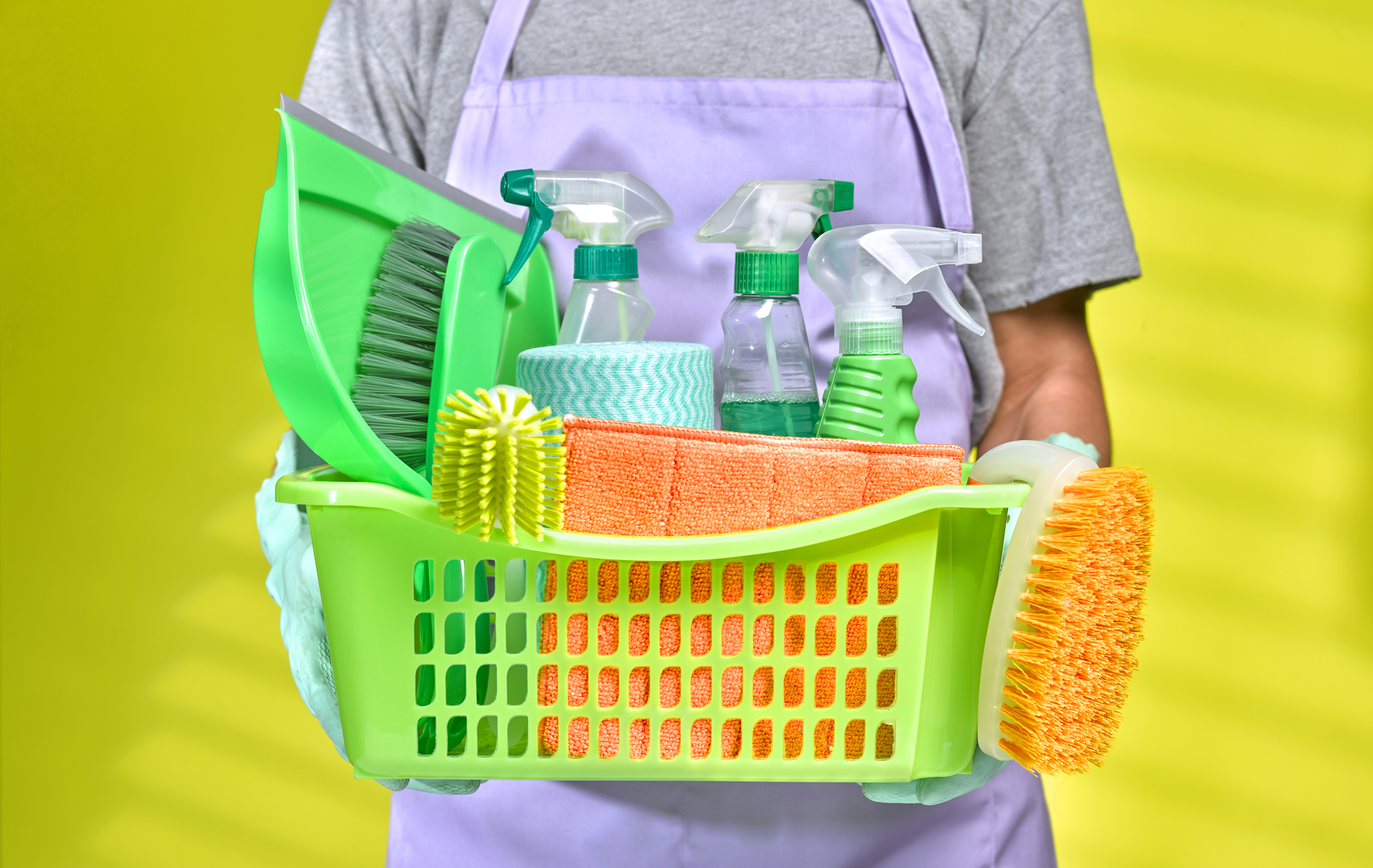 Man holding a basket of cleaning products