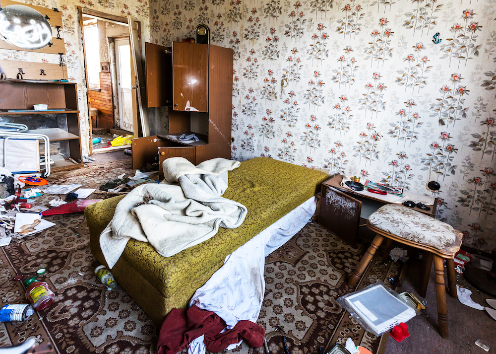 shabby room with floral wallpaper and debris