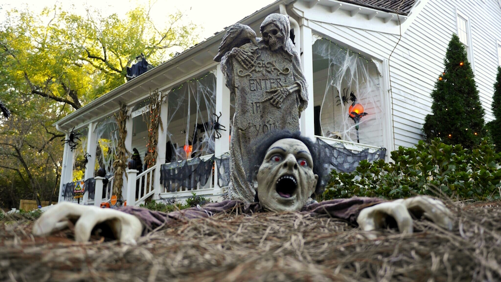 Halloween graveyard display on white house with front porch