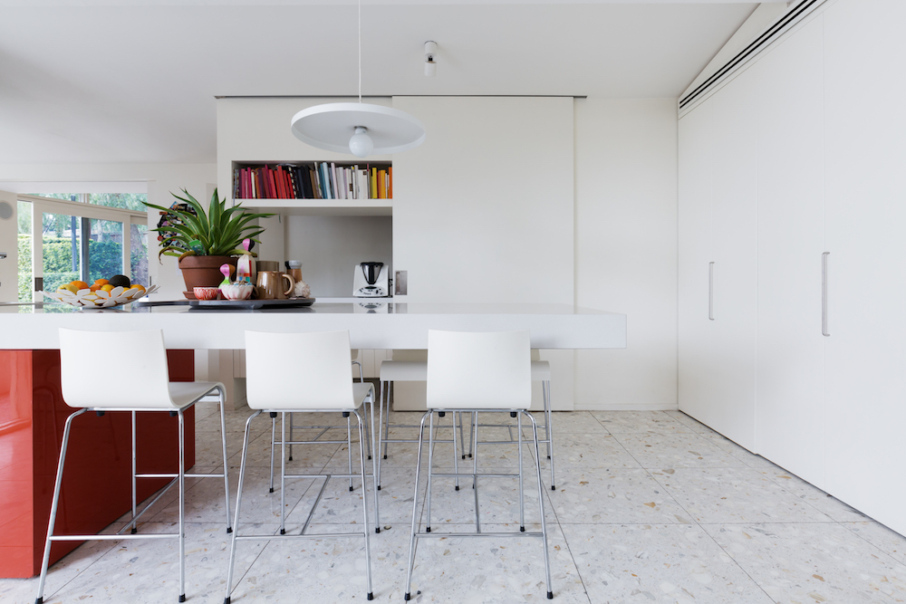 white kitchen with red cabinets and terrazzo floor