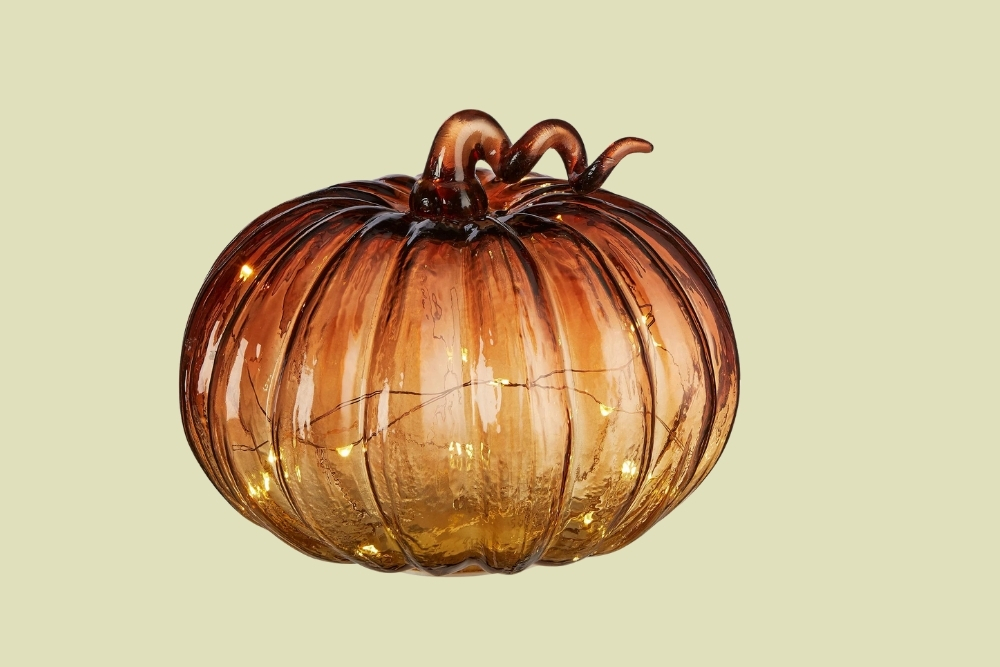 Orange and gold glass pumpkin with string lights