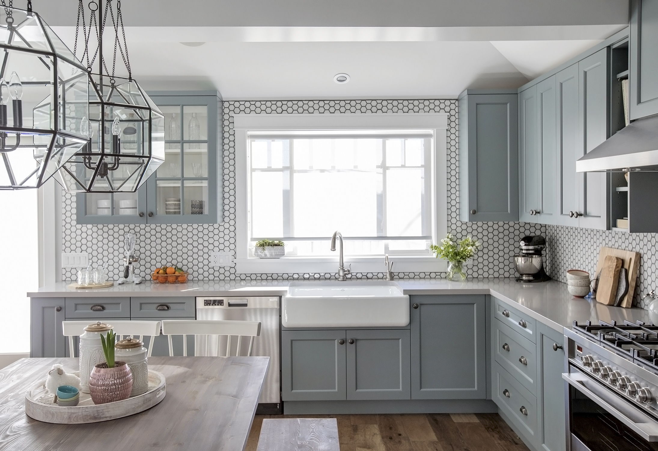 Grey kitchen featuring shaker cabinets, an apron sink and a smattering of stylish hexagon tiles
