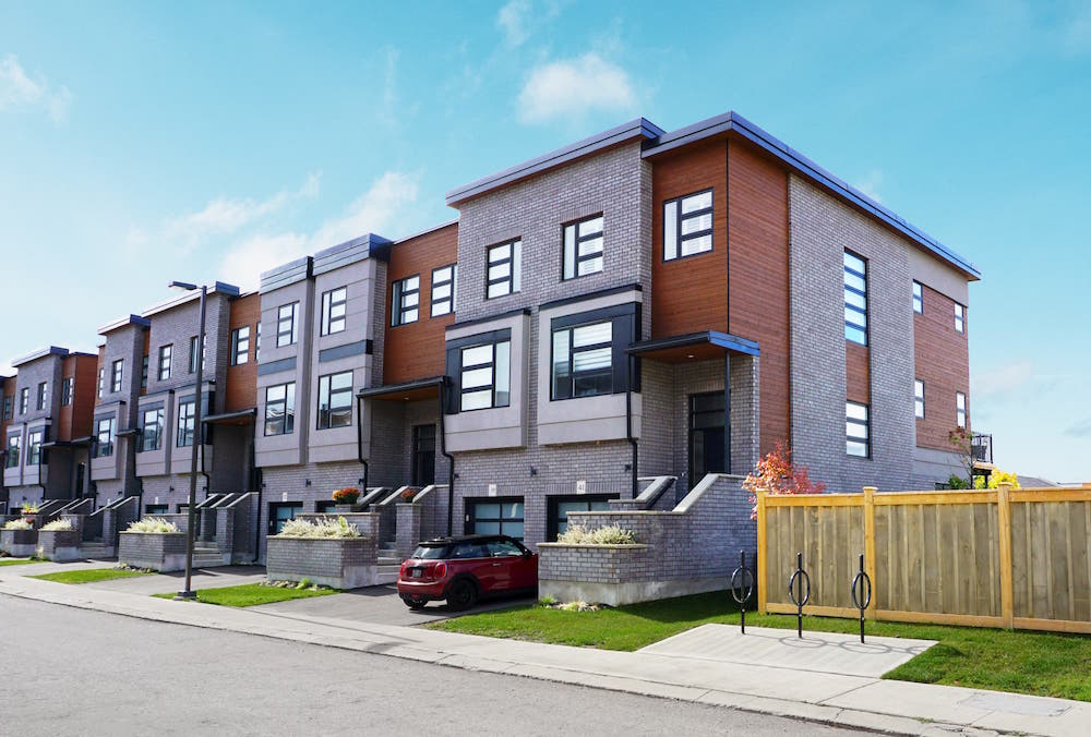 exterior of block of modern brick townhomes on sunny day